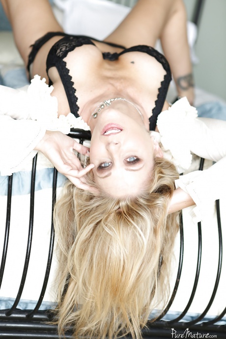 Зрелая красотка Джулия Энн лежит на кровати и мастурбирует свою киску 4