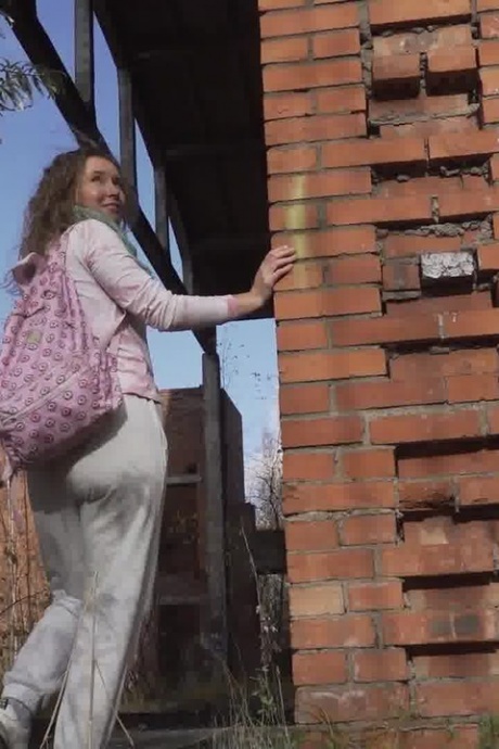 Белая девушка Рита отходит в туалет за заброшенным кирпичным зданием 15