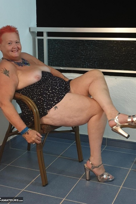 Толстая бабуля с короткими рыжими волосами прижимается своими большими сиськами и задницей к стеклу 6