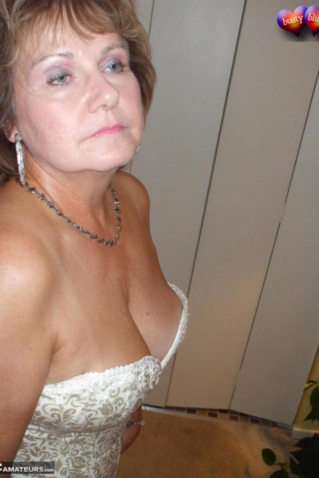 Зрелая женщина позирует обнаженной в корсете и нейлоновых чулках с подвязками 11