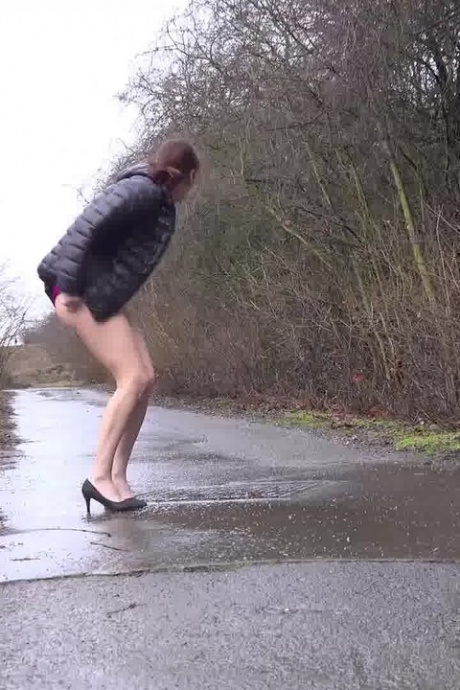 Коротко стриженная девушка Антония Сайнс писает на мокрую дорогу с задранным платьем 13