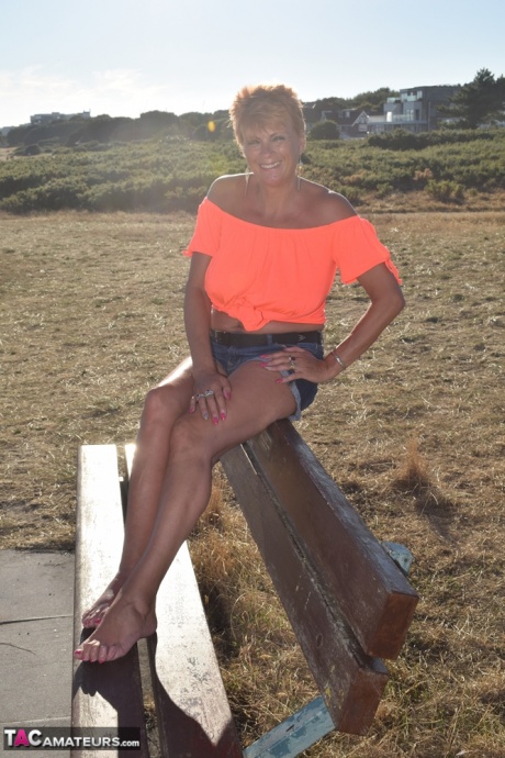 Зрелая рыжеволосая Димонти показывает свои сиськи на скамейке в загородном поле 19