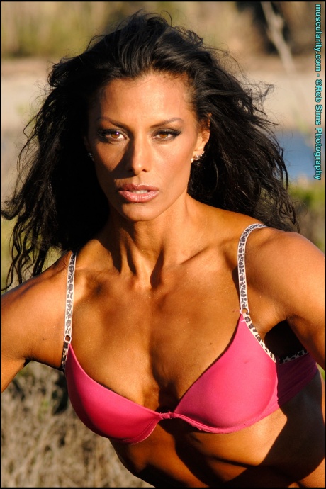 Брюнетка-культуристка Дейдре Пагнанелли позирует на обгоревшем пне в поле 14