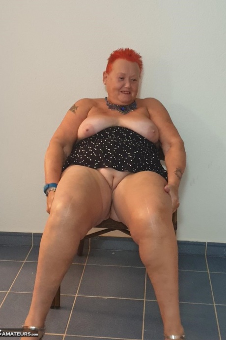 Толстая бабуля с короткими рыжими волосами прижимается своими большими сиськами и задницей к стеклу 13