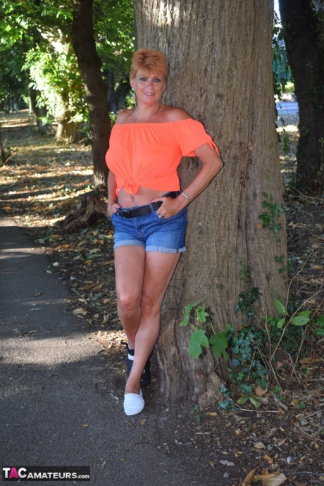 Зрелая рыжеволосая Димонти показывает свои сиськи на скамейке в загородном поле 9