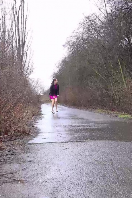 Коротко стриженная девушка Антония Сайнс писает на мокрую дорогу с задранным платьем 1