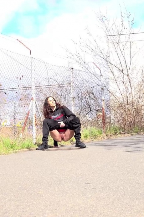Белая девушка Али Бордо днем срочно отходит в туалет на асфальтированной дороге 2
