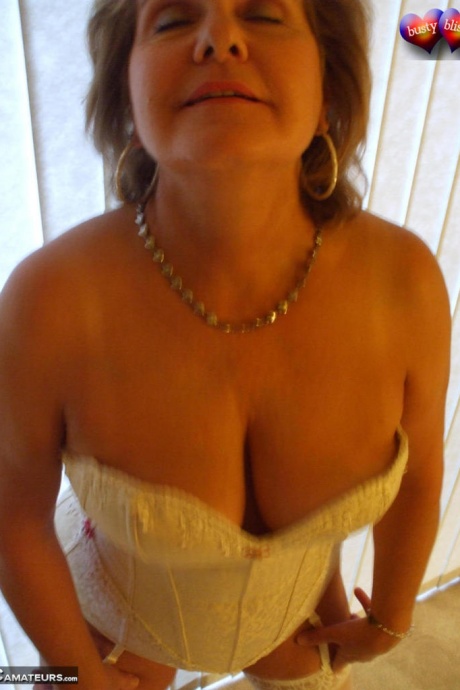 Зрелая женщина позирует обнаженной в корсете и нейлоновых чулках с подвязками 12