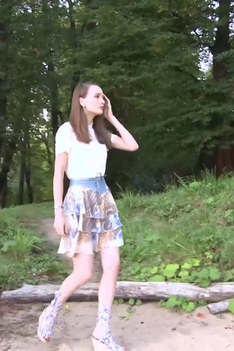 Брюнетка Оксана садится на корточки на бордюре, чтобы пописать 1