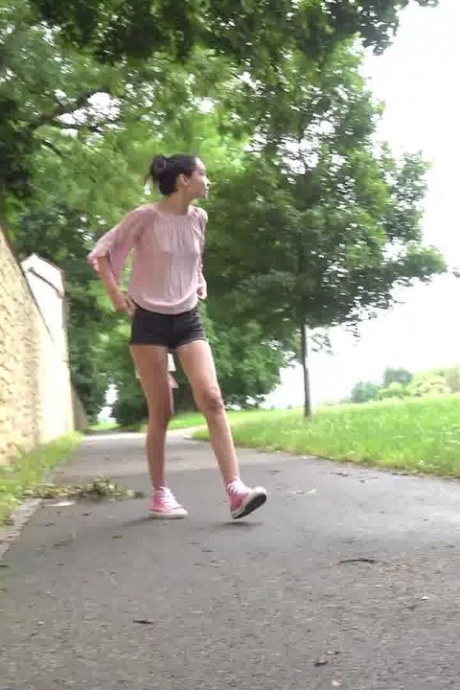 Коротко снятая девушка Мистика садится на корточки, чтобы пописать, на мощеной дорожке в городской обстановке 14