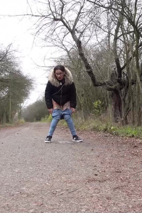 Девушка-одиночка Наташа Инк садится на корточки, чтобы пописать, на проселочной дороге, одетая в парку 13