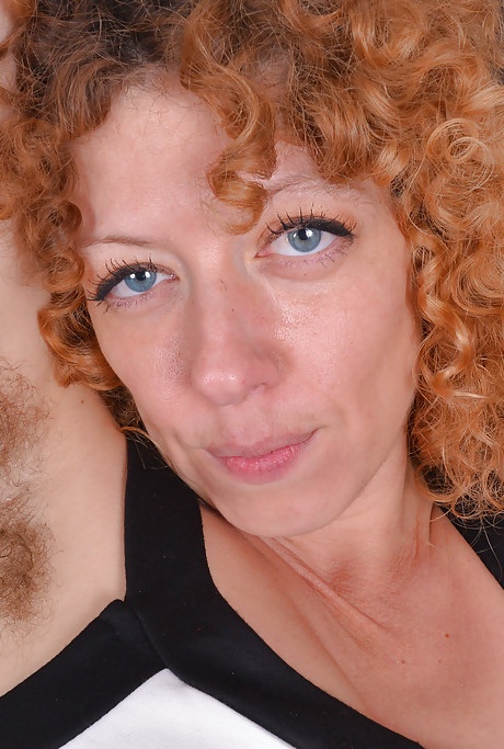 Зрелая рыжая с маленькими сиськами демонстрирует волосатые подмышки и вагину 1