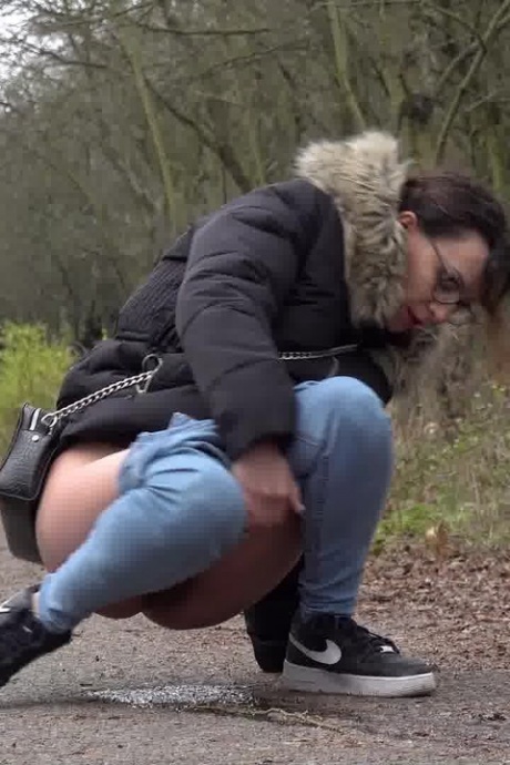 Девушка-одиночка Наташа Инк садится на корточки, чтобы пописать, на проселочной дороге, одетая в парку 11