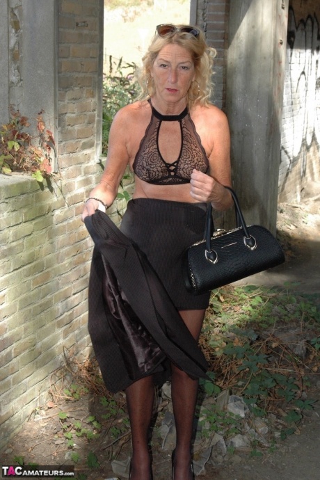 Зрелая блондинка Кирас Нейлонс позирует на шпильках в чулочно-носочных изделиях и черной юбке 7