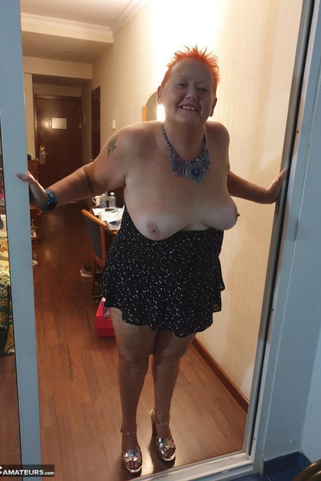 Толстая бабуля с короткими рыжими волосами прижимается своими большими сиськами и задницей к стеклу 17