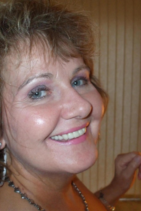 Зрелая женщина позирует обнаженной в корсете и нейлоновых чулках с подвязками 5