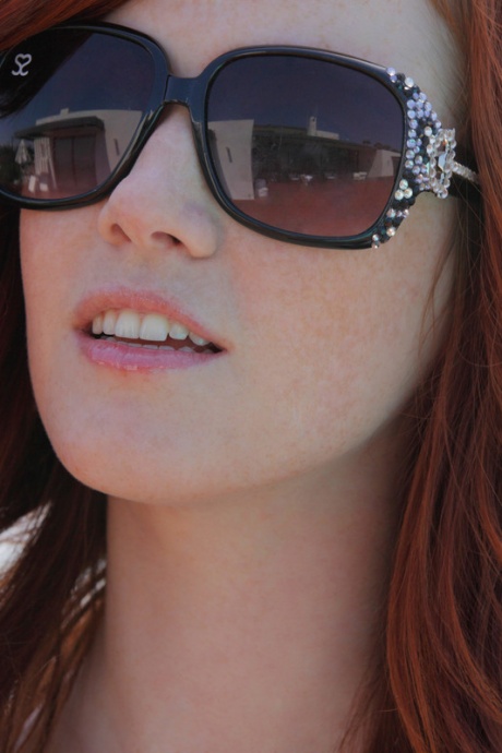 Натуральная рыжеволосая Элли мастурбирует свою возбужденную киску обнаженной на солнышке 1