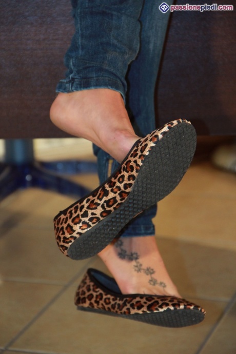 Одинокая девушка в джинсах и куртке освобождает босые ноги от туфель на плоской подошве 4