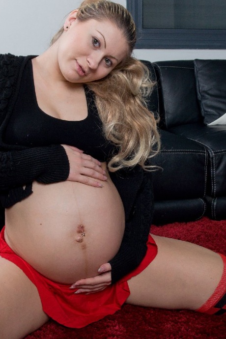 Беременная девушка показывает свой большой живот перед тем, как раздеться в носках OTK 6